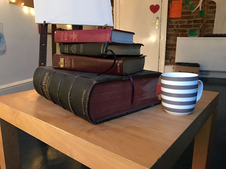 a picture of theological books and the bible with a cup of tea.